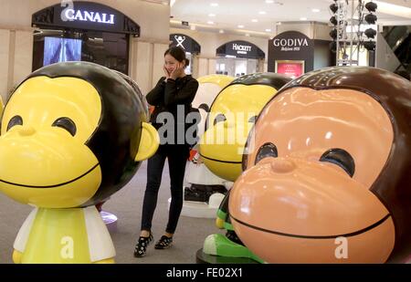 (160203) -- Shanghai, Febbraio 3, 2016 (Xinhua) -- una ragazza in posa per una foto tra monkey figurine presso il Centro Commerciale Westgate su Nanjing West Road a Shanghai in Cina orientale, Febbraio 3, 2016. Un totale di 100 incantevole figurine di scimmia sono stati collocati su Nanjing West Road, di una prospera commerciale street, a Shanghai, per creare un nuovo anno atmosfera. (Xinhua/Liu Ying) (lfj) Foto Stock