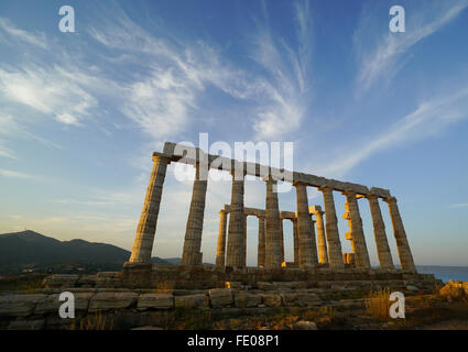 Tempio di Poseidone a Capo Sounion, nella provincia di Attica, Grecia durante il golden ora prima del tramonto sotto le nuvole whispy Foto Stock
