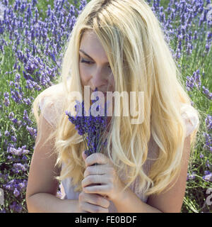 Donna su un prato con dei fiori di lavanda Foto Stock