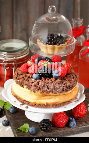 Cheesecake al cioccolato topping decorati con frutta estiva: lamponi, fragole, mirtilli e more. Foto Stock