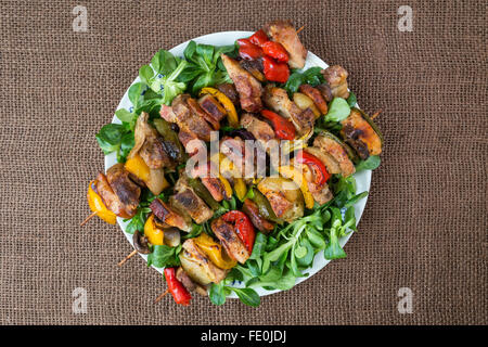 Grigliate gli spiedini di carne su un piatto di verdure Foto Stock