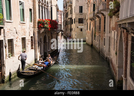 Gondoliere sulla sua gondola lungo il Rio de S.Luca, uno dei tanti canali interni di Venezia nel nord Italia Foto Stock