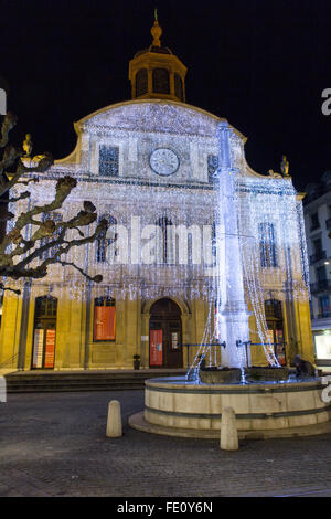 Ginevra, Svizzera - 13 dicembre 2014: La fontana Fusterie e tempio di notte illuminata con decorazioni di Natale. Foto Stock