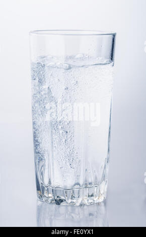 Bicchiere di acqua minerale bolle isolati su sfondo bianco Foto Stock