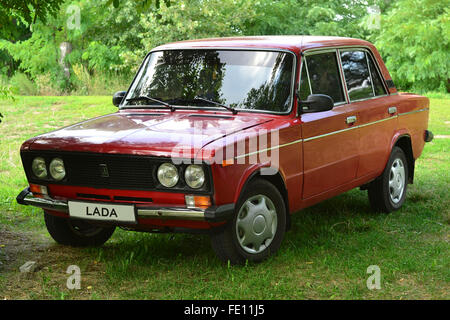 Rosso auto sovietica Lada Vaz-1600 parcheggiato sotto gli alberi Foto Stock