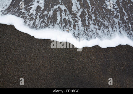 Spiaggia di sabbia nera con schiuma d'onda texture in Fuerteventura a Isole Canarie Foto Stock