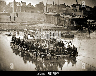 Union Army artiglieria, artiglieri e venti soldati di fanteria Varcando il fiume su una zattera durante gli Stati Uniti dalla guerra civile Foto Stock