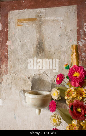 L'acqua santa font e fiori di cera nella chiesa del paese, Teotitlan del Valle, Oaxaca, Messico Foto Stock