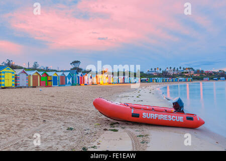 Bagnino rosso barca di salvataggio su una spiaggia con colorate cabine, Melbourne, Australia Foto Stock