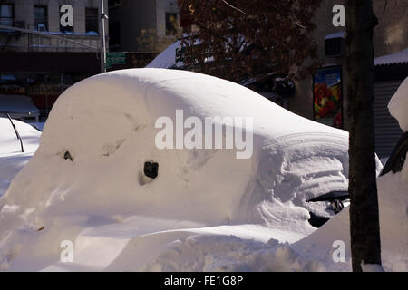 Una coperta di neve veicolo ancora essere scavata su una strada di città dopo una notte di tempesta di neve con condizioni di blizzard sepolto Foto Stock