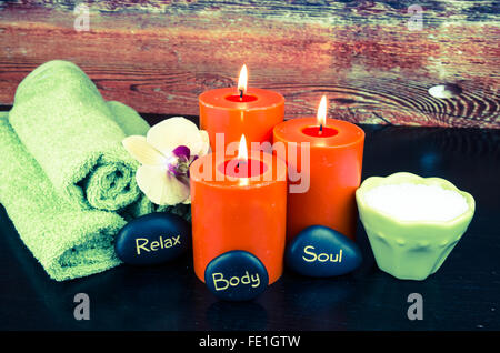 Masterizzazione di candele arancione,orchid pietra lavica e asciugamano still life Foto Stock