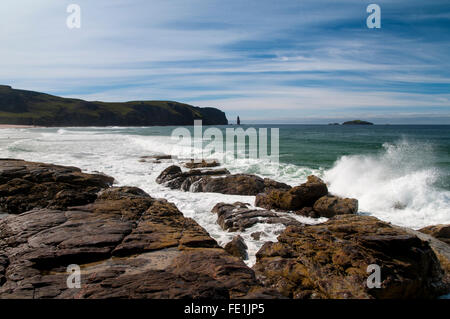 Atlantic di onde che si infrangono sulle rocce Shanabhait Tràigh, la spiaggia a Sandwood Bay, con il promontorio di Rubh' un Bhuachaille un Foto Stock