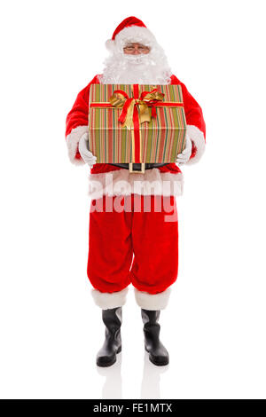 Babbo Natale tenendo un grande regalo presente con nastri e bow, isolata su uno sfondo bianco. Foto Stock