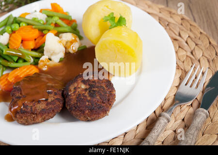 Polpette fritte su una piastra con verdure e patate Foto Stock