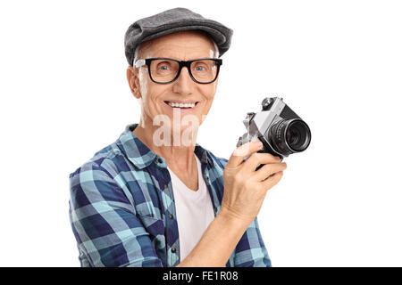 Studio shot di una gioiosa senior uomo con una telecamera e sorridente isolati su sfondo bianco Foto Stock