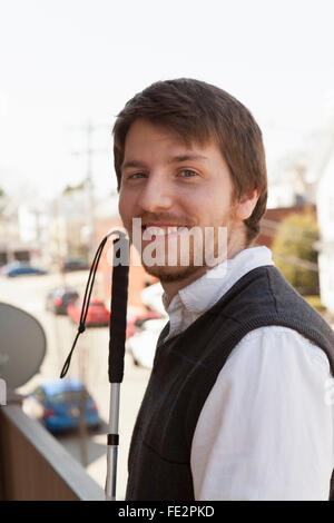 I giovani ciechi uomo a camminare in città Foto Stock