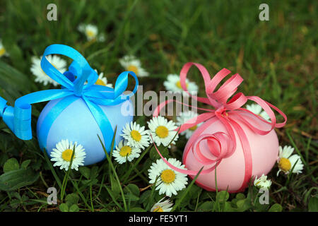 Dipinto di uova di Pasqua in erba con margherite Foto Stock