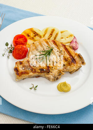 Braciole di maiale alla griglia con anelli di cipolla e senape, vista dall'alto Foto Stock