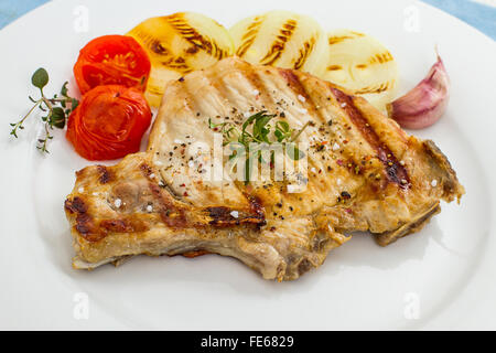 Succosa braciole di maiale alla griglia con anelli di cipolla, vista dall'alto Foto Stock