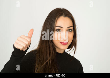 Attraente fiducioso giovane donna dando positivo Thumbs up gesto Foto Stock