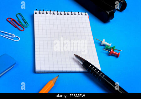 Notebook e delle forniture di ufficio su sfondo Foto Stock