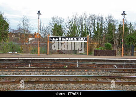 Vecchia Stazione di legno segno in bianco e nero montato sulla piattaforma fino a Leamington Spa stazione all'interno di due vecchi lampioni. Foto Stock