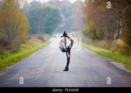 Young Professional rende ginnasta si divide su strada a tempo di autunno Foto Stock