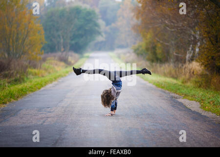 Young Professional rende ginnasta si divide su strada a tempo di autunno Foto Stock