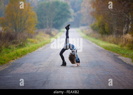 Young Professional rende ginnasta si divide su strada a tempo di autunno Foto Stock