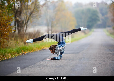 Young Professional rende ginnasta si divide su strada a tempo di autunno Foto Stock