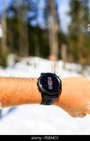 Guida sul sentiero di montagna guardando il cronometro smartwatch, activity monitor tracker, controllo delle prestazioni o la frequenza cardiaca impulso. Foto Stock