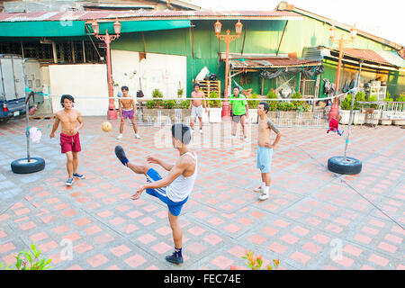 Thai uomini e ragazzi giocare Sepak Takraw o Kick volley a pallavolo gioco ma con i piedi a Bangkok, in Thailandia. Foto Stock