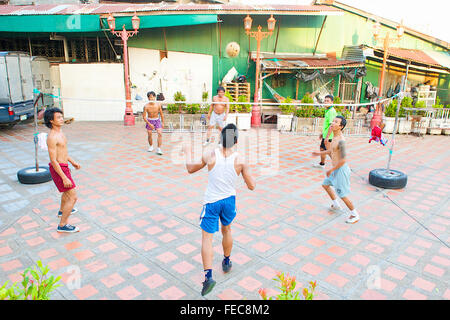 Thai uomini e ragazzi giocare Sepak Takraw o Kick volley a pallavolo gioco ma con i piedi a Bangkok, in Thailandia. Foto Stock