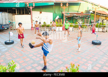 Thai uomini e ragazzi giocare Sepak Takraw o Kick volley a pallavolo gioco ma con i piedi a Bangkok, in Thailandia. Foto Stock