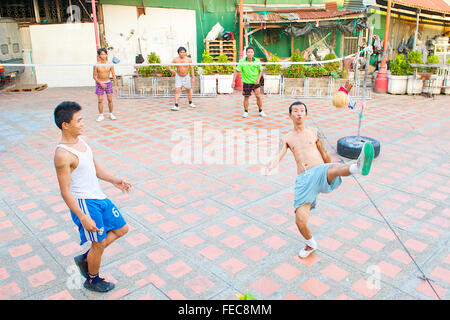 Thai uomini e ragazzi giocare Sepak Takraw o Kick volley a pallavolo gioco ma con i piedi a Bangkok, in Thailandia. Foto Stock