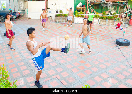 Thai uomini e ragazzi giocare Sepak Takraw o Kick volley a pallavolo gioco ma con i piedi a Bangkok, in Thailandia. Foto Stock