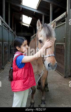 Ritratto di una bambina con il suo pony preferito Foto Stock