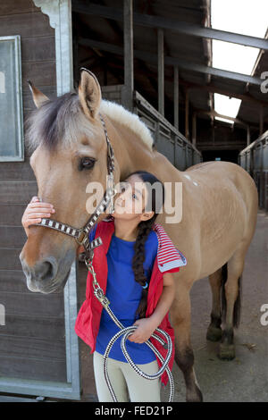 Ritratto di una bambina con il suo pony preferito Foto Stock