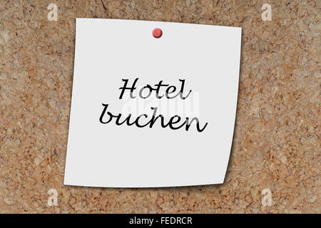 Hotel buchen (tedesco fare una prenotazione in hotel) scritto su un memo imperniata su una bacheca di sughero Foto Stock