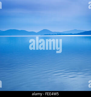 Superficie di acqua in una mattina blu sul lago Trasimeno, Umbria Italia. Colline sullo sfondo. Foto Stock