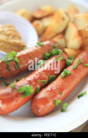 Salsicce con lo scalogno tritato e home-patate fritte con mostarda Foto Stock