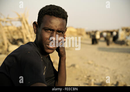 Giovane africano uomo seduto nel villaggio di Ahmed Ela, Danakil depressione, regione di Afar, Etiopia Foto Stock
