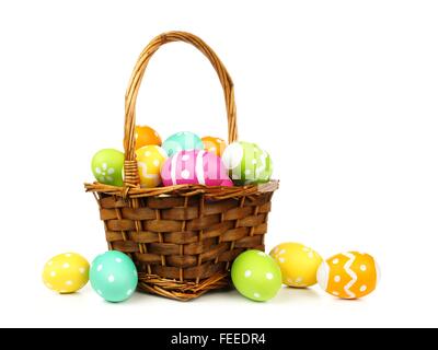 Pasqua cesto pieno di uova colorate su sfondo bianco Foto Stock