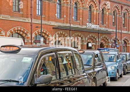 Una linea di nero iconico Londra taxi attendere al di fuori di St Pancras International Station, punto di arrivo per Eurostar e servizi ferroviari nazionali. Foto Stock