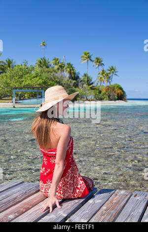 Donna seduta sul molo, Tetamanu, Fakarava, isole Tuamotu, Polinesia Francese Foto Stock