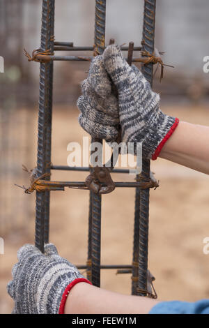 Chiusura del lavoratore edile mani lavorando con pinze su fixin Foto Stock