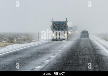 Pomeriggio nevoso su una trafficata autostrada con il traffico e la scarsa visibilità per un inverno di concetto di attenzione Foto Stock