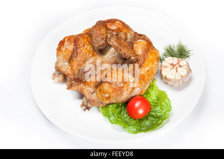 Pollo fritto su bianco piatti con pomodoro, aglio e foglia verde Foto Stock