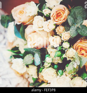 La lussureggiante Bouquet con crema e bianco e rose fresche foglie verdi. Il concetto di matrimonio. Messa a fuoco selettiva, profondità di campo. Foto Stock