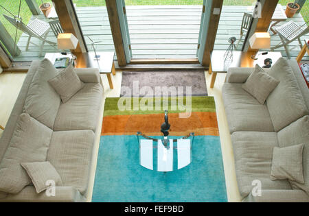Zona soggiorno, morbidi divani, porte vetrate sul ponte. Foto Stock